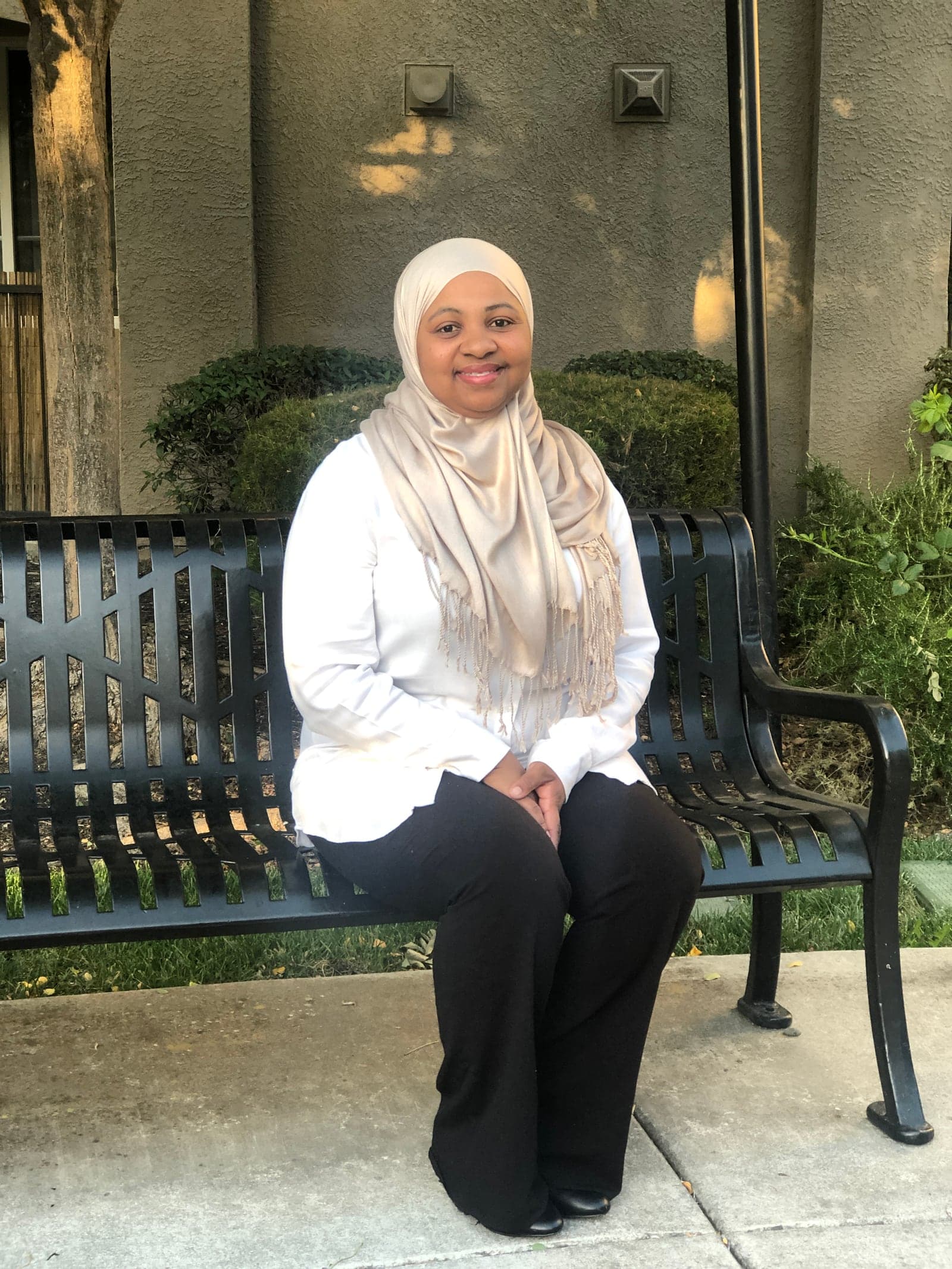 Ruqayyah seated outdoors.