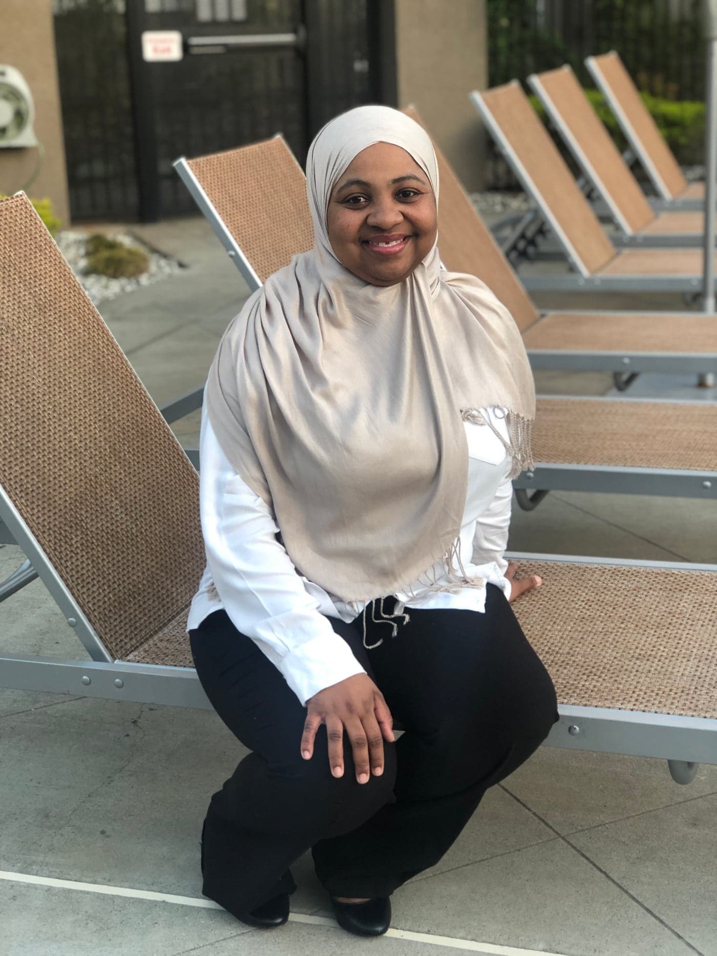 Ruqayyah seated outdoors.